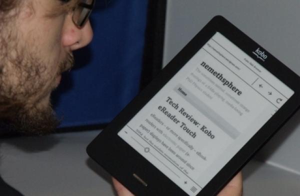 Me looking at a Kobo Touch e-ink screen displaying the current article.